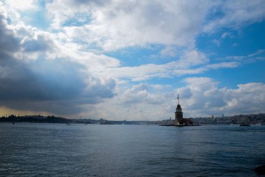 İstanbul Boğazı 'nda yüzen turist tekneli Maiden Tower veya Kiz Kulesi. İstanbul 'un tarihi işareti Bakire Kulesi