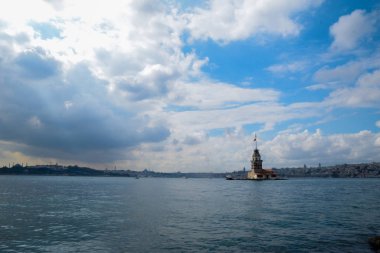 İstanbul Boğazı 'nda yüzen turist tekneli Maiden Tower veya Kiz Kulesi. İstanbul 'un tarihi işareti Bakire Kulesi