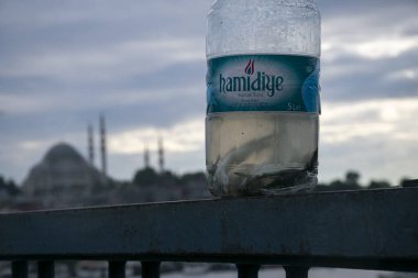 Fotoğraf 28 Haziran 2018 'de çekildi: Balıklı ve arka plan manzaralı boş su şişesi. Amidiye su şişesi..