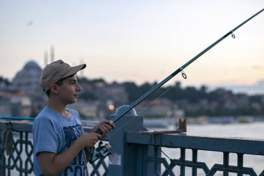 Fotoğraf 28 Haziran 2018 'de çekildi: İstanbul' daki Galata Köprüsü 'nde küçük balıkçılar balık tutuyor