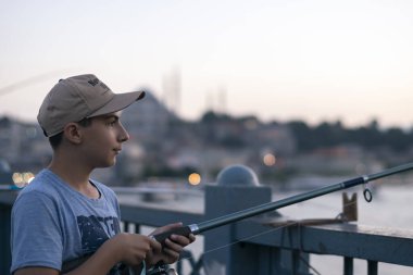 Fotoğraf 28 Haziran 2018 'de çekildi: İstanbul' daki Galata Köprüsü 'nde küçük balıkçılar balık tutuyor