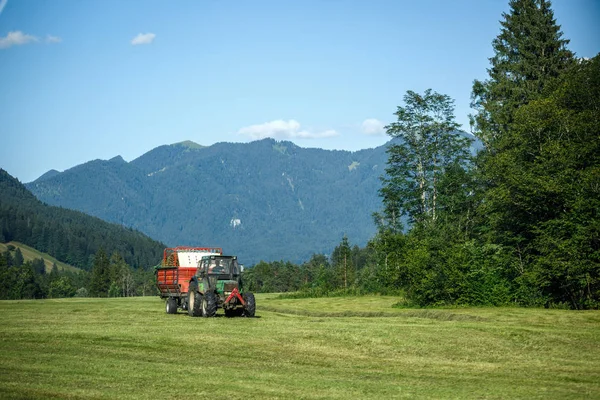 草地上的旧拖拉机。在阿尔卑斯山的美丽山景 — 图库照片