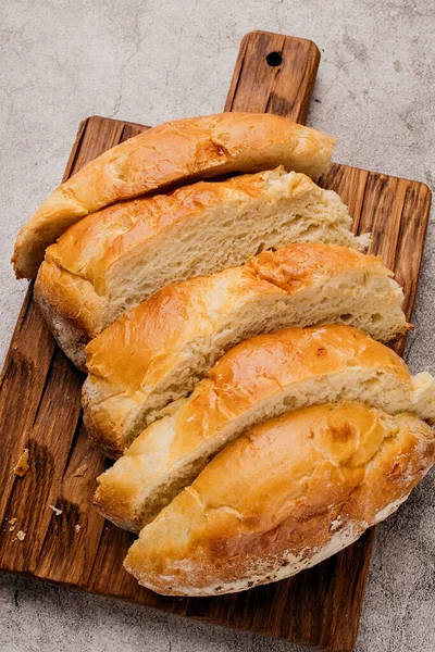 Bucăți de pâine albă rotundă mare pe o placă de tăiere din lemn . — Fotografie, imagine de stoc