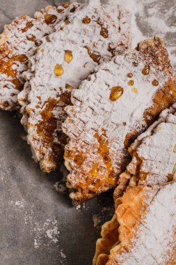 Fresh-baked waffles with powdered sugar and honey for breakfast