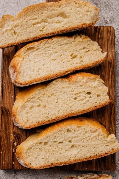 Bucăți de pâine albă rotundă mare pe o placă de tăiere din lemn . — Fotografie, imagine de stoc