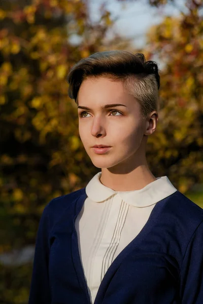 Trendy teen girl with short hair in autumn park — Stockfoto
