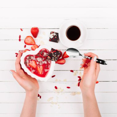 Bir kalp şeklinde bir kase çilek güler yüzlü. Sağlıklı ve lezzetli kahvaltı