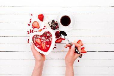 Bir kalp şeklinde bir kase çilek güler yüzlü. Sevgililer günü. Tatil Kahvaltı