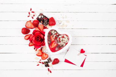 Bir kalp ve Sevgililer kartı şeklinde bir kase çilek güler yüzlü. Sağlıklı ve lezzetli kahvaltı