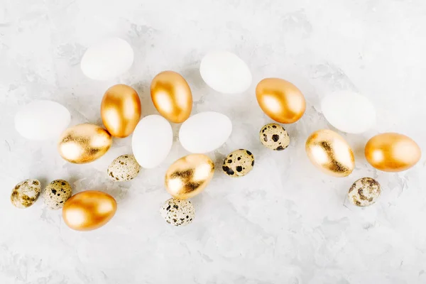 Painted Easter golden eggs and quail   eggs on a marble background. Holiday background. Flat lay, top view — Stock Photo, Image