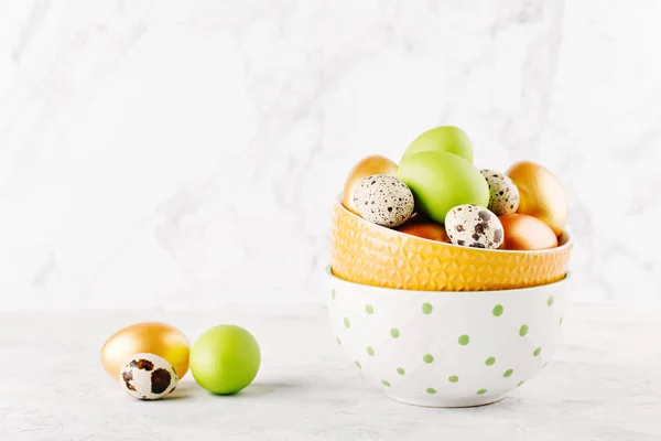 Mangkuk dengan warna-warni telur Paskah pada latar belakang marmer . — Stok Foto