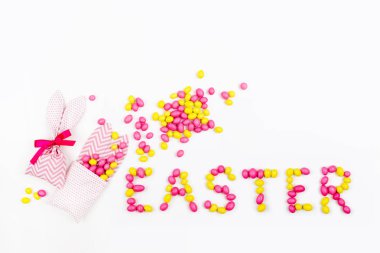 Bunny çanta pembe ve sarı şeker ve beyaz arka plan üzerinde beyaz arka plan üzerinde Paskalya yazı ile tedavi