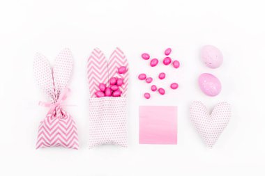 Bunny treat bag with pink candy, empty card, eggs and heart.  Easter concept on white background clipart