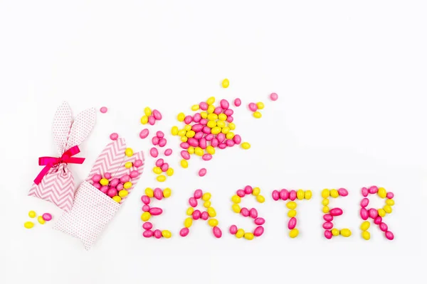 Bunny Leckertüten mit rosa und gelben Bonbons und Schriftzug Ostern auf weißem Hintergrund auf weißem Hintergrund — Stockfoto