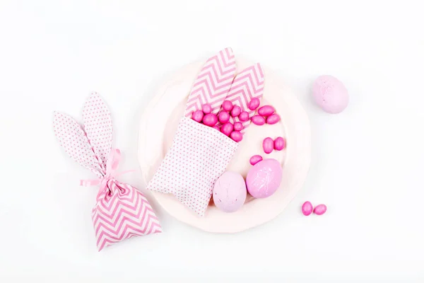 Накрытие пасхального стола. Красные яйца Банни лечить сумку с розовыми конфетами. Плоский, вид сверху — стоковое фото