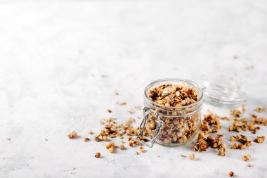Sağlıklı kahvaltı için cam kavanozda fındık ve çekirdekli ev yapımı granola.