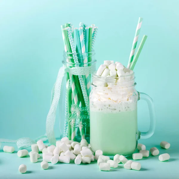 Batido de hortelã de leite em um jarro de vidro com marshmallows em um fundo azul — Fotografia de Stock