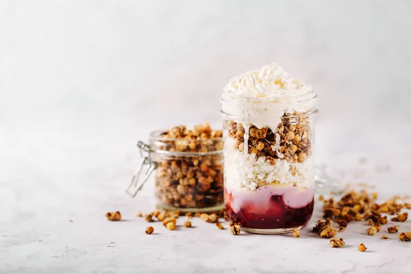 Café da manhã saudável com granola e creme em um frasco de vidro — Fotografia de Stock