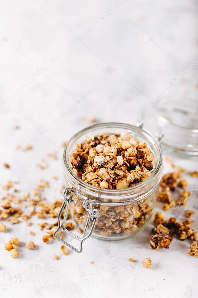Healthy breakfast. Fresh granola  in a glass jar on a gray background.