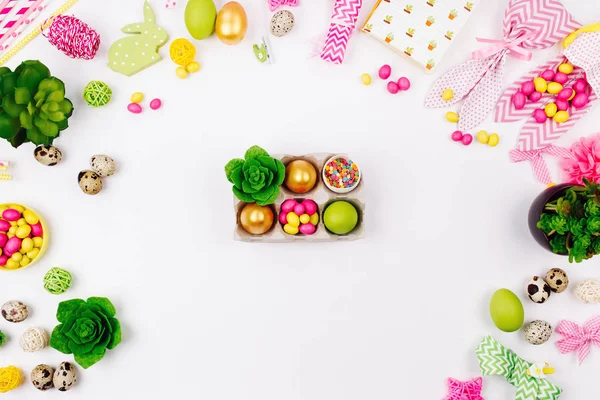Telur Paskah, permen dan lezat dalam baki kertas pada latar belakang dekorasi musim semi. Letak datar, tilikan atas — Stok Foto