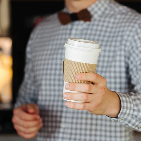 Un barista masculino sosteniendo una taza de café de papel — Foto de Stock