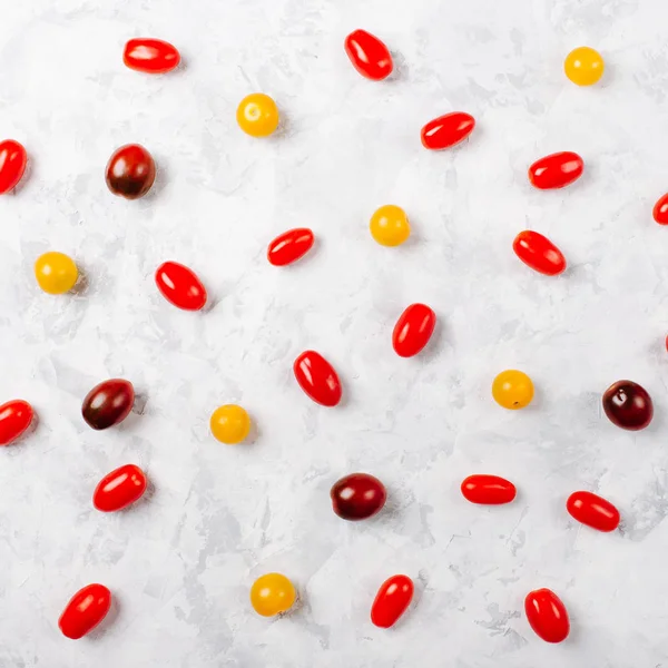 Tomates cherry rojos y amarillos. Patrón alimenticio sobre fondo blanco. Puesta plana . — Foto de Stock