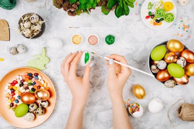 El Paskalya yumurtaları boya. Paskalya dekorasyonu ile çalışma alanı. Tepsiler, şeker, kopya alanı çiçeklerle boyalı yumurtalar. Düz yatıyordu, en iyi görünümü