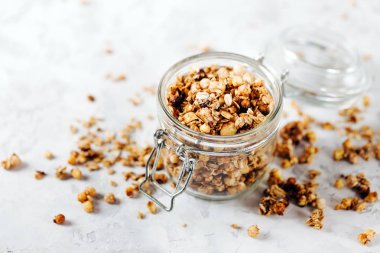 Sağlıklı kahvaltı. Gri bir arka plan üzerinde bir cam kavanoza taze granola.