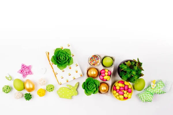 Werkruimte met Pasen decoratie. Beschilderde eieren in trays, snoep, bloemen, sappige met kopie ruimte. Lente achtergrond. Plat lag, top uitzicht — Stockfoto