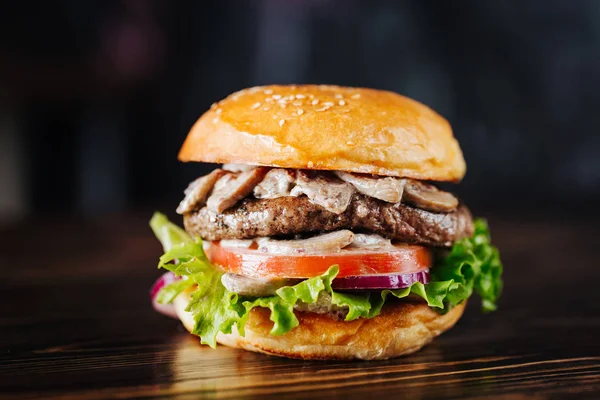 Burger con funghi, polpette, pomodoro e lattuga su fondo di legno. Da vicino. — Foto Stock