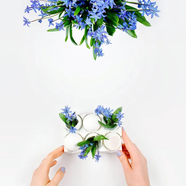 Hände halten Tablett mit Blumen und Eiern — Stockfoto