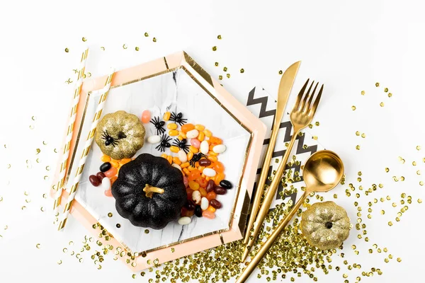 Gericht mit Süßigkeiten mit schwarzem und goldenem Kürbis. — Stockfoto
