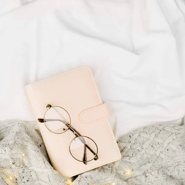 Cuaderno y anteojos en la cama — Foto de Stock