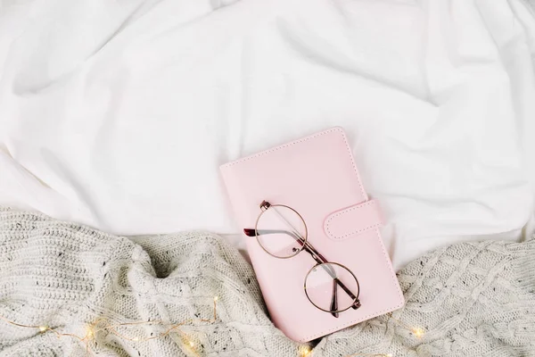 Cuaderno y anteojos en la cama — Foto de Stock
