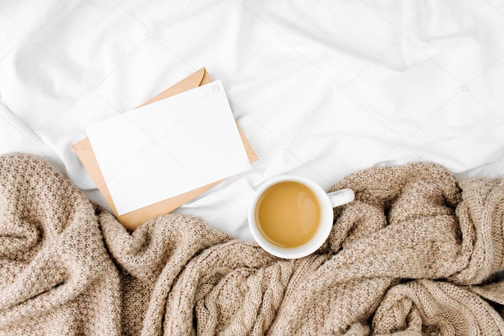 Blank card and coffee on bed