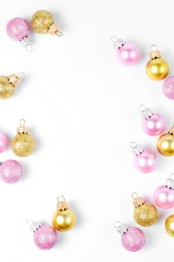 Pembe ve altın Noel topları beyaz arka plan üzerinde çerçeve yapılmış