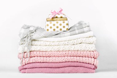 Hediye kutusu beyaz zemin üzerine sıcak giysiler yığını üzerinde