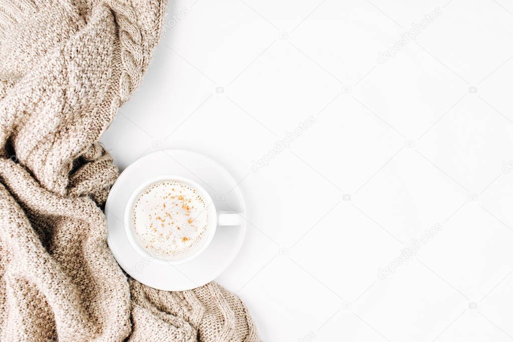 Cup of delicious cappuccino on bed with warm plaid. Copy space 