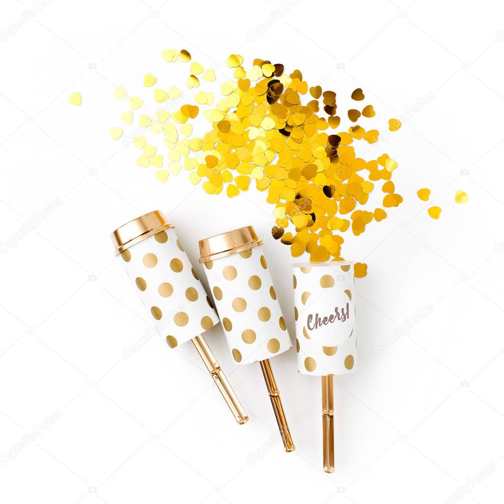 festive golden confetti and crackers on white background 