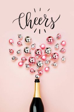 Şampanya şişesi, pembe görünümünü top ve Şerefe, pembe arka plan izole yazı ile Noel topları gümüş