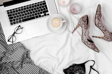 Dizüstü bilgisayarlı ve kadın aksesuarlı moda blogcusu çalışma alanı. düz yatış, üst görünüm