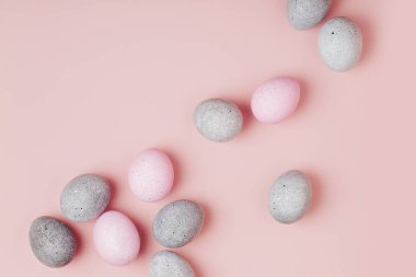 Pastel arka plan üzerinde soluk pembe ve gri Paskalya yumurtaları grup. Düz yatıyordu 