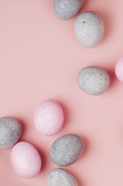 Pastel arka plan üzerinde soluk pembe ve gri Paskalya yumurtaları grup. Düz yatıyordu 