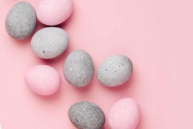 Pastel arka plan üzerinde soluk pembe ve gri Paskalya yumurtaları grup. Düz yatıyordu 