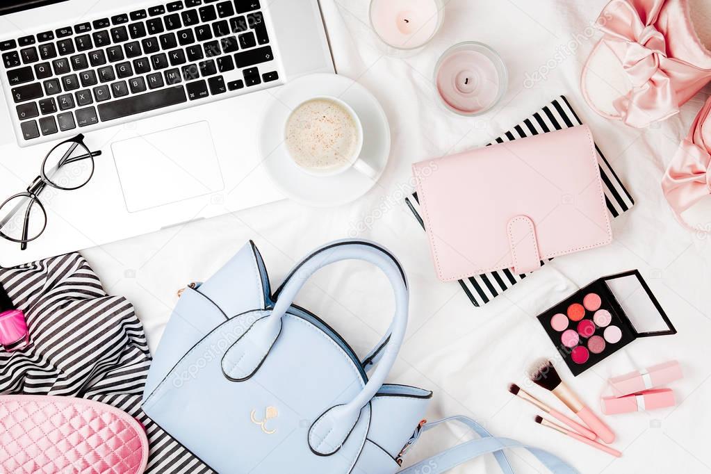 Fashion blogger workspace with laptop and woman accessory in bed. flat lay,  top view