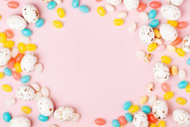 Şık çerçeve şeker çikolata yumurta ve jelibon, pembe arka plan yapılmış