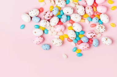 Şeker çikolata yumurta ve pembe bir arka plan üzerinde Jellybean