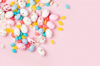 Şeker çikolata yumurta ve pembe bir arka plan üzerinde Jellybean