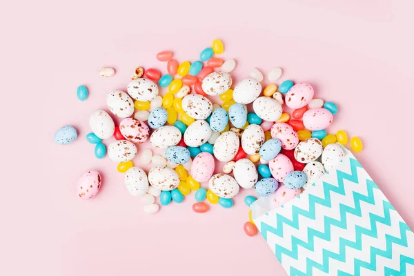 Velikonoční Cukroví Čokoládová Vajíčka Jellybean Vyplývající Strany Papírový Sáček Růžovém — Stock fotografie