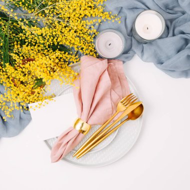 Festival Tablo ayarı. Tabak ve çatal bıçak takımı gri dekoratif Tekstil ve beyaz zemin üzerine sarı çiçekleri ile. Güzel aranjman.